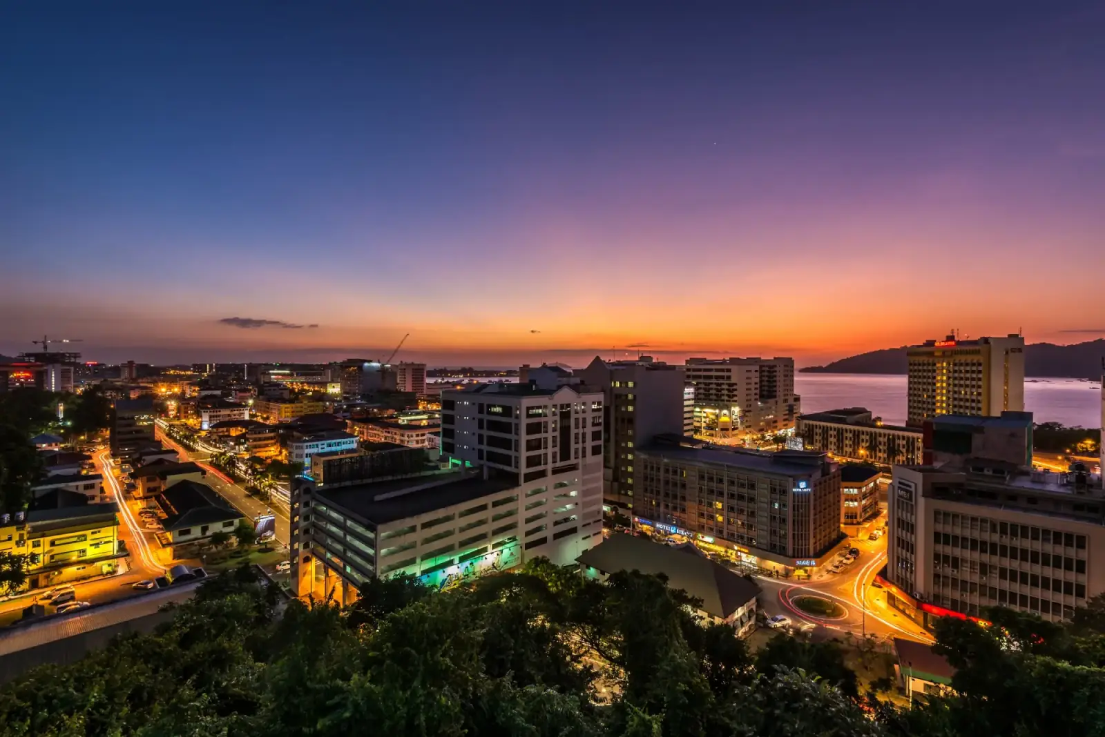 Kota Kinabalu city lights at dusk, with the sea beyond